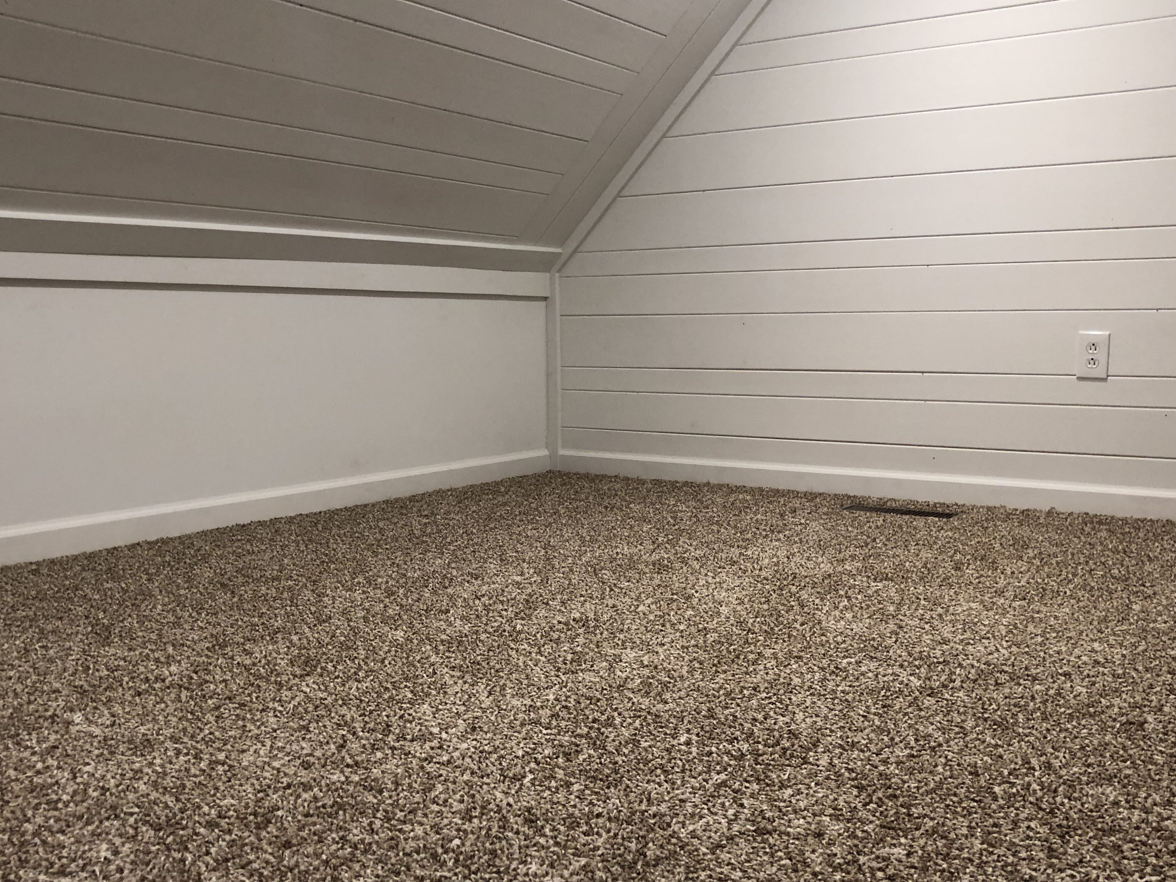 Upstairs attic bedroom with freshly installed carpet.