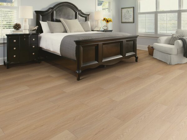 Room scene showing off Distinction Plus Timeless Oak Luxury Vinyl Plank flooring from Shaw Flooring in a bedroom.