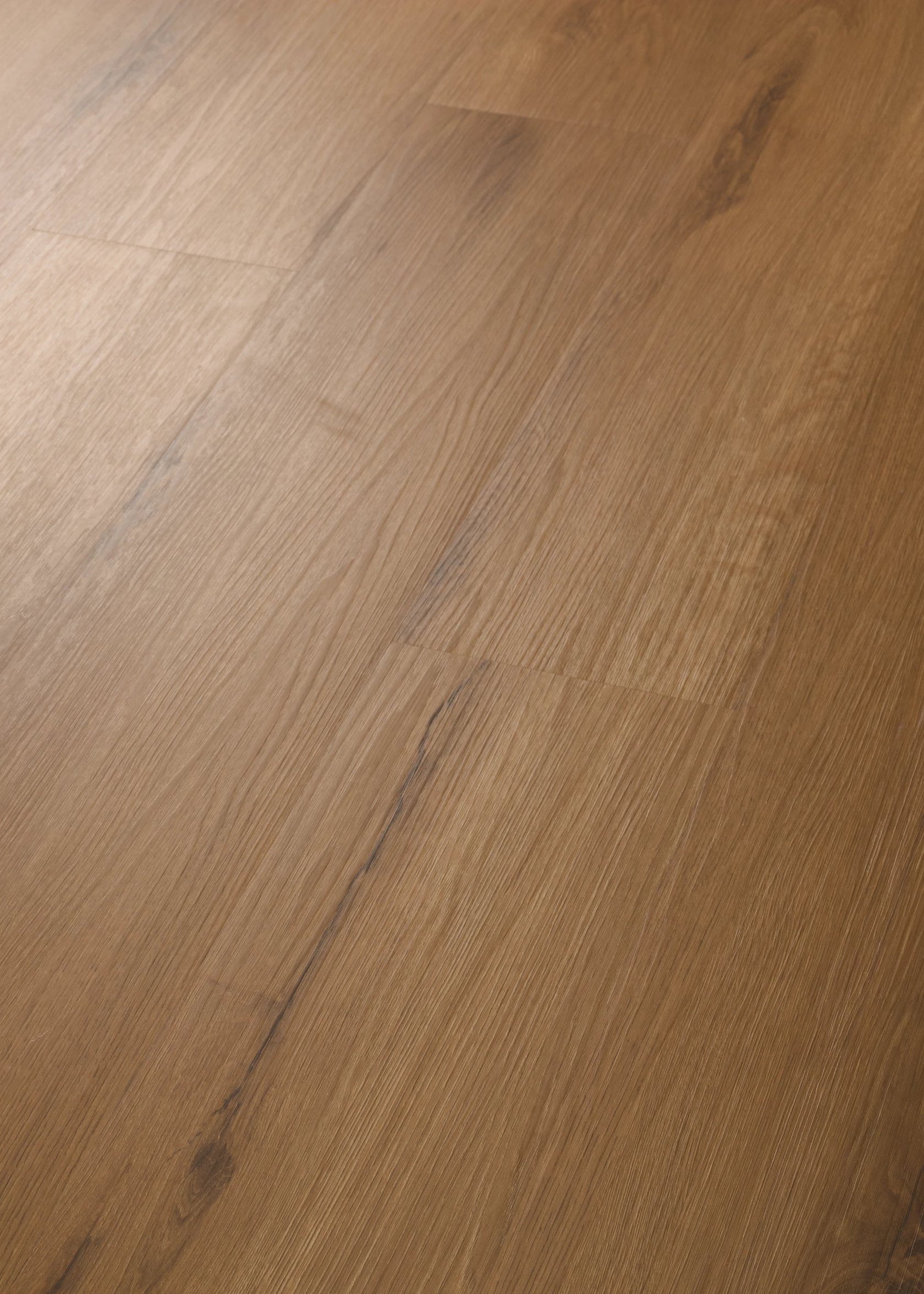 Shaw Fleetwood glue down luxury vinyl plank in Harvest Oak, close up plank shot at an angle.